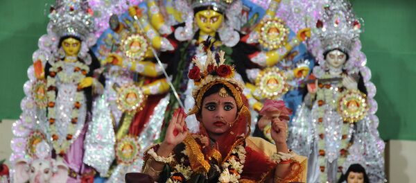 A young Indian Hindu unmarried girl, Nilanjana Chakraborty (5), known as a 'kumari' and dressed as the Hindu goddess Durga, puts her hand up during a ritual for the Durga Puja festival at Ramakrishna Mission in Agartala, the capital of northeastern state of Tripura on October 21, 2015 A young Indian Hindu unmarried girl, Nilanjana Chakraborty (5), known as a 'kumari' and dressed as the Hindu goddess Durga, puts her hand up during a ritual for the Durga Puja festival at Ramakrishna Mission in Agartala, the capital of northeastern state of Tripura on October 21, 2015 - اسپوتنیک افغانستان