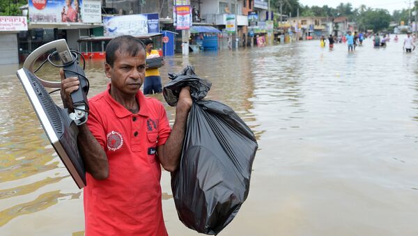 Мужчина с вещами на затопленной улице в пригороде Коломбо, Шри-Ланка - اسپوتنیک افغانستان  