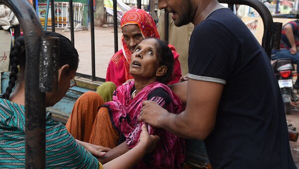رهگذران به خانم گرمازده در کراچی کمک های اولیه را انجام میدهند - اسپوتنیک افغانستان  