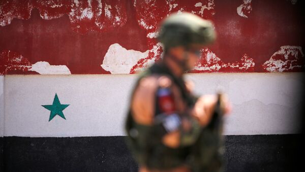 A Russian soldier stands guard near a Syrian national flag drawn on the wall as rebel fighters and their families evacuate the besieged Waer district in the central Syrian city of Homs, after an agreement reached between rebels and Syria's army, Syria May 21, 2017 - اسپوتنیک افغانستان  