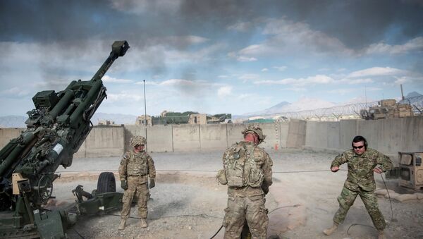 This photo taken on May 28, 2014 shows US Army Sergeant (retired) Joshua Ben, of Missouri (R) who lost his leg to an Rocket Propelled Grenade (RPG) in Afghanistan’s Jalrez Valley in 2007, firing artillery during 'Operation Proper Exit' at Forward Operating Base Shank in Afghanistan's Logar Province - اسپوتنیک افغانستان  