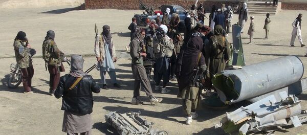 Taliban militants stand next to the wreckage of components jettisoned by a damaged aircraft, which the militants say they had hit. - اسپوتنیک افغانستان  