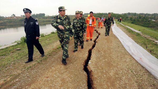 In this photo released by China's Xinhua News Agency, rescuers inspect a crack at Fengshou reservoir dam, caused by Monday's 7.9 magnitude earthquake in Anxian County, southwest China's Sichuan Province, in May 2008. - اسپوتنیک افغانستان  