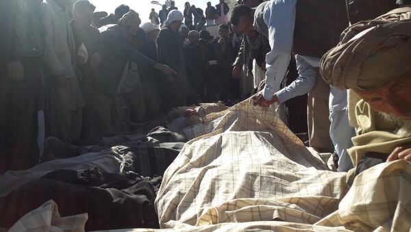 Afghan men gather around the bodies of civilians, including children who were killed by Islamic State militants in Ghor province on October 26, 2016 - اسپوتنیک افغانستان  