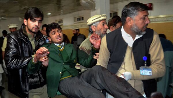 Pakistani volunteers carry a student injured in the shootout at a school under attack by Taliban gunmen, at a local hospital in Peshawar, Pakistan - اسپوتنیک افغانستان  