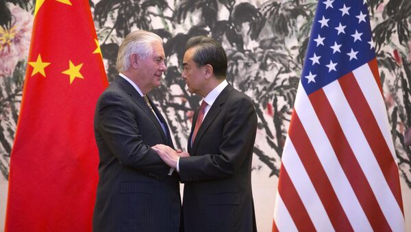 U.S. Secretary of State Rex Tillerson, left, and Chinese Foreign Minister Wang Yi stare at each other as they shake hands at the end of a joint press conference following their meeting at the Diaoyutai State Guesthouse in Beijing, China, Saturday, March 18, 2017 - اسپوتنیک افغانستان  
