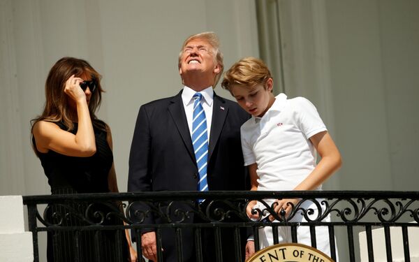دونالد ترامپ رئیس جمهور ایالات متحده امریکا با همسرش ملانی و پسرش در هنگام مشاهده  خورشیدگرفتگی در کاخ سفید - اسپوتنیک افغانستان  
