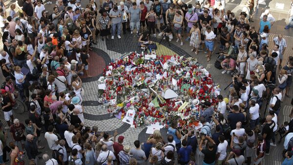 People gather at a memorial tribute of flowers, messages and candles to the victims on Barcelona's historic Las Ramblas promenade on the Joan Miro mosaic, embedded in the pavement where the van stopped after killing at least 13 people in Barcelona , Spain, Friday, Aug. 18, 2017 - اسپوتنیک افغانستان  