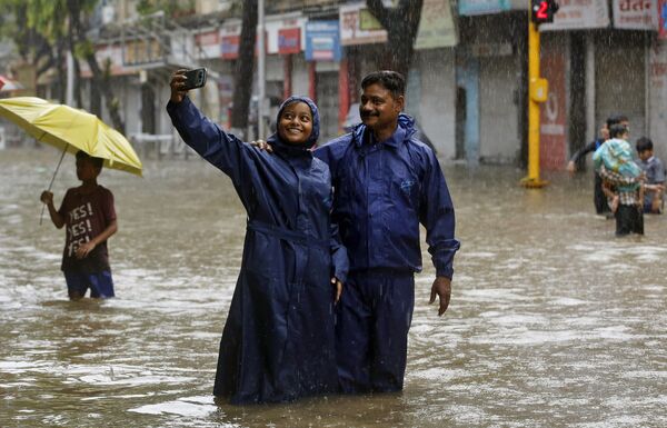 باشندگان هند سیلف ها را د خیابان غرق شده در اب در مومبای عکاسی میکنند - اسپوتنیک افغانستان  