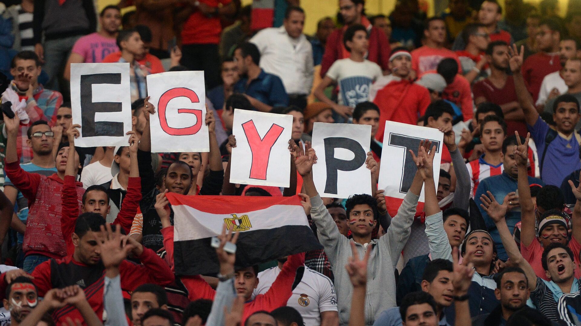Egyptian fans carry placards and the national flag ahead of the match between Egypt and Senegal during the Africa Cup of Nations group G football match at the Cairo International Stadium in the Egyptian capital on November 15, 2014 - اسپوتنیک افغانستان  , 1920, 07.02.2022