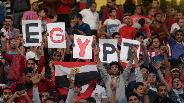 Egyptian fans carry placards and the national flag ahead of the match between Egypt and Senegal during the Africa Cup of Nations group G football match at the Cairo International Stadium in the Egyptian capital on November 15, 2014 - اسپوتنیک افغانستان  