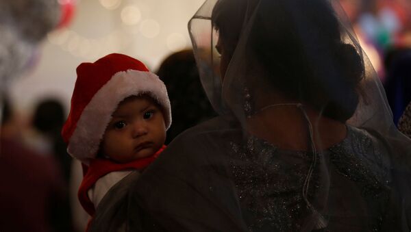 Женщина с ребенком в церкви во время празднования Рождества в Пакистане - اسپوتنیک افغانستان  