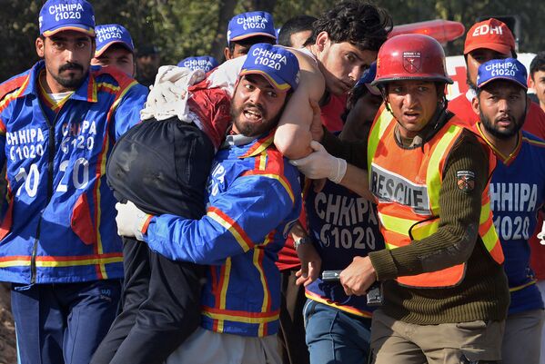 داوطلبان زخمی را پس از حمله طالبان به دانشگاه در پیشاور پاکستان حمل می کنند - اسپوتنیک افغانستان  