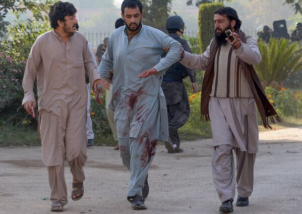 مردان پاکستانی پس از حمله ستیزه جویان طالبان در پیشاور در 1 دسمبر 2017، بر دانشگاه کشاورزی، به زخمی شدن کمک می کنند. - اسپوتنیک افغانستان  