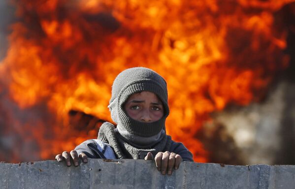 پسر فلسطینی که در جریان درگیری میان اسرائیلی ها و فلسطینی ها در کرانه باختری در نزدیکی شهر نابلس پنهان شده - اسپوتنیک افغانستان  