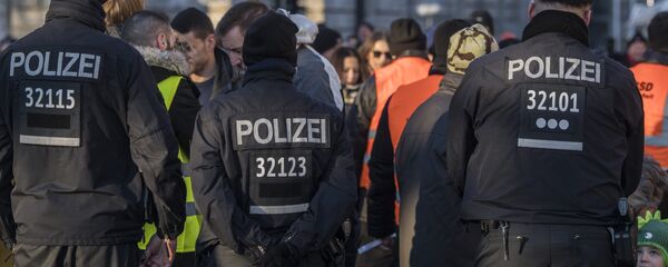 German police officers watch over a security check near the capital's Brandenburg Gate on December 31, 2016, as revellers arrive for New Year celebrations - اسپوتنیک افغانستان  