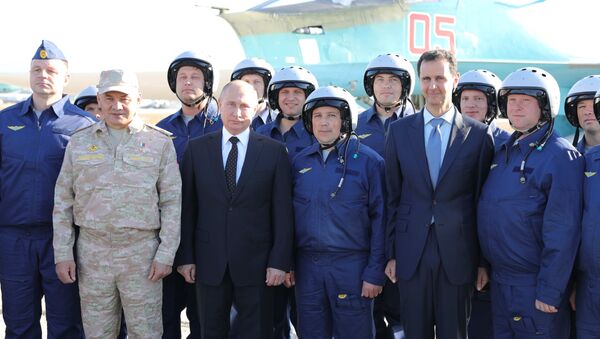 Президент РФ Владимир Путин и президент Сирийской Арабской Республики Башар Асад с российскими военнослужащими во время посещения авиабазы Хмеймим в Сирии - اسپوتنیک افغانستان  
