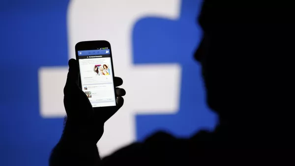 Мужчина рассматривает страницу в Facebook на своем смартфоне - اسپوتنیک افغانستان  