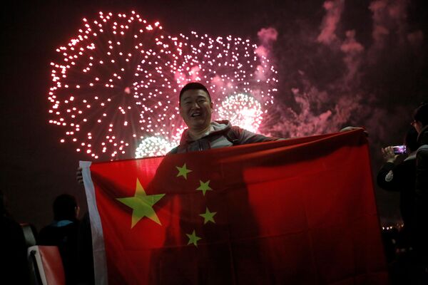 مردی با پرچم چین، در جریان آتش‌بازی به افتخار سال نو چینی در نیویارک - اسپوتنیک افغانستان  