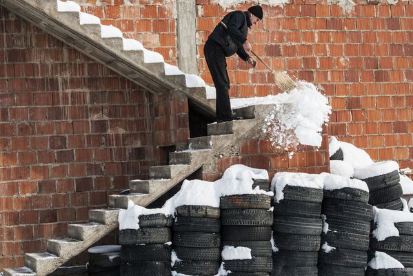 مردی در حال برف پاکی در صربستان. - اسپوتنیک افغانستان  
