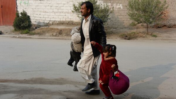 Афганский мужчина убегает с места взрыва с двумя детьми - اسپوتنیک افغانستان  