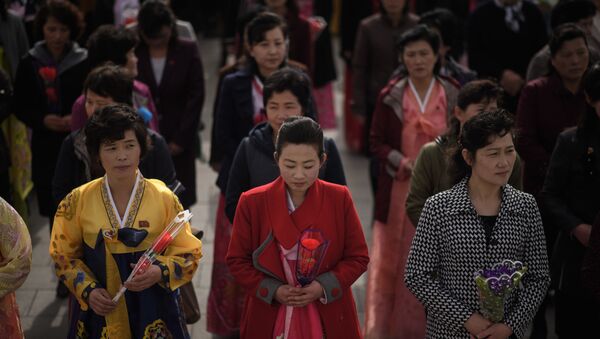 نثار گل به پای مجسمه رهبر کوریای شمالی در پیونگ یانگ در زمان جشن خورشید . - اسپوتنیک افغانستان  