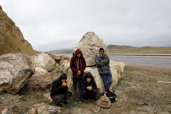 گروه از مهاجران افغان در حال انتظار بس، پس از عبور از سرحدهای ترکیه و ایران در آغری، ترکیه - اسپوتنیک افغانستان  