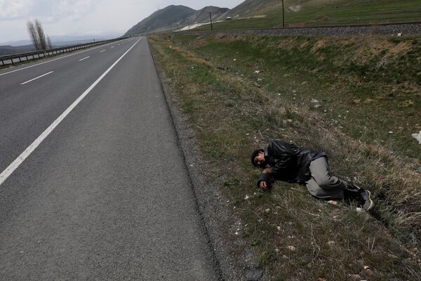 مهاجر افغان در حال استراحت در کنار جاده پس از عبور از مرزهای ترکیه و ایران در نزدیکی شهر ارزروم، ترکیه - اسپوتنیک افغانستان  