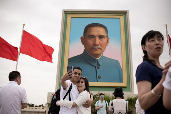 زوجی در حال سلفی گرفتن با تصویر سون یات سن، سیاستمدار و انقلابی چینایی – بیجینگ، چین - اسپوتنیک افغانستان  