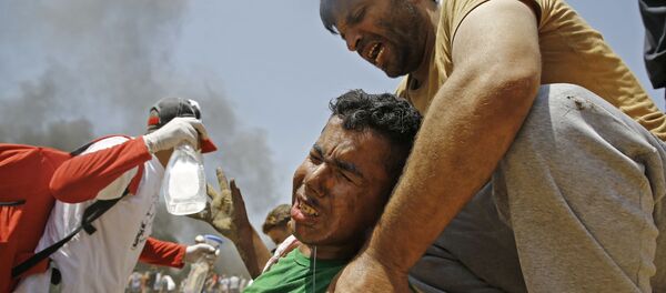 فلسطینی به جوان زخمی شده در درگیری با نیروهای اسرائیل کمک می کند فلسطینی به جوان زخمی شده در درگیری با نیروهای اسرائیل کمک می کند - اسپوتنیک افغانستان