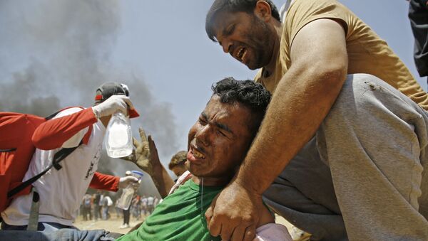 فلسطینی به جوان زخمی شده در درگیری با نیروهای اسرائیل کمک می کند - اسپوتنیک افغانستان  