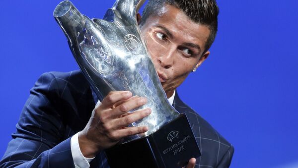 Игрок ФК Реал Мадрид Криштиану Роналду целует полученный трофей за лучшего игрока года по мнению УЕФА - اسپوتنیک افغانستان  