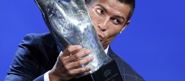 Игрок ФК Реал Мадрид Криштиану Роналду целует полученный трофей за лучшего игрока года по мнению УЕФА - اسپوتنیک افغانستان  