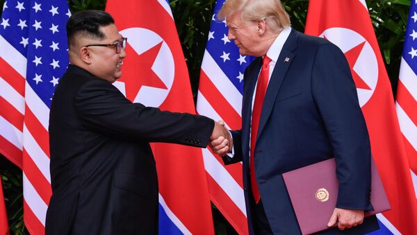 U.S. President Donald Trump and North Korea's leader Kim Jong Un shake hands during the signing of a document after their summit at the Capella Hotel on Sentosa island in Singapore June 12, 2018 - اسپوتنیک افغانستان  