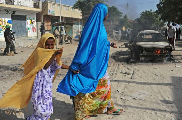 زنی همراه با دختر خردسال خود در کنار موتر منفجر شده – شهر واردخیگلی، موگادیشو - اسپوتنیک افغانستان  