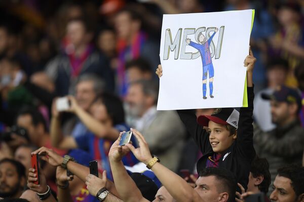 هوادار کوچک مهاجم بارسلونا با تصویر که در آن مسی نقاشی شده است در بازی رئال و بارسا از این مهاجم با نمایش این تصویر از وی حمایت میکند - اسپوتنیک افغانستان  