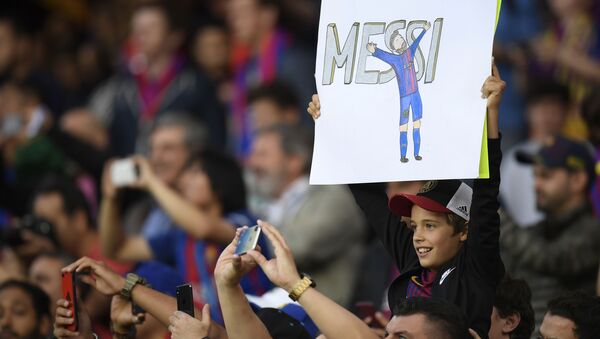 Юный болельщик с плакатом с изображнием форварда Барселоны Лионеля Месси перед матчем между Барселоной и Реал Мадридом в Барселоне - اسپوتنیک افغانستان  