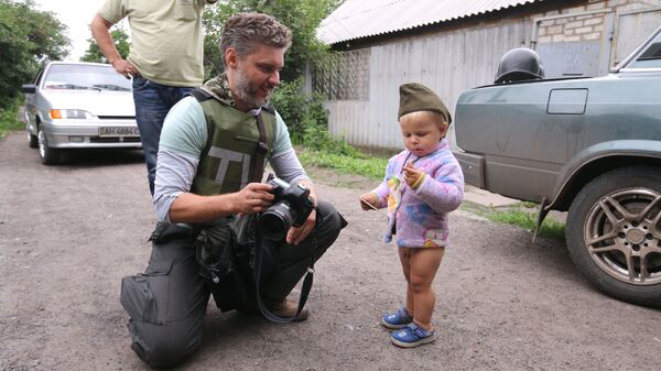 Специальный фотокорреспондент МИА Россия сегодня Андрей Стенин и мальчик Антон Кобченко в селе Семеновка, Донбасс, 2014 год - اسپوتنیک افغانستان  