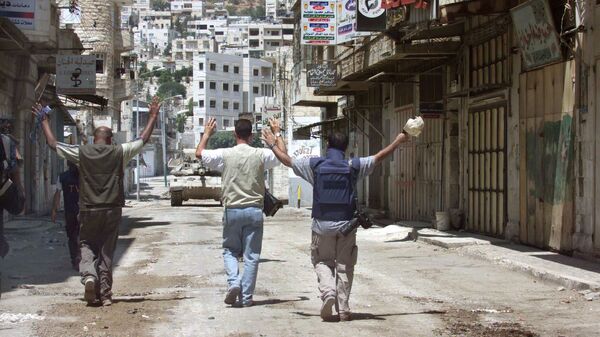 Журналисты с поднятыми руками идут по направлению к израильскому танку на одной из улиц в центре города Наблус, 2002 год - اسپوتنیک افغانستان  