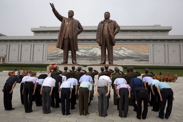مردم کوریای شمالی در حال ادای احترام به مجسه های کیم ایل سونگ و کیم جونگ ایل رهبران پیشین این کشور - اسپوتنیک افغانستان  