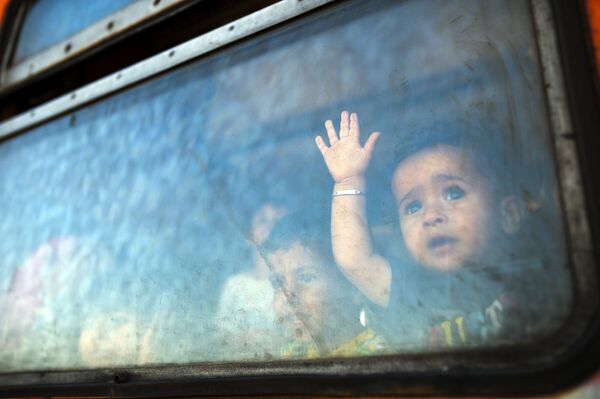 کودکان مهاجرین از کلکین موتر سرویس به سرحد مقدونیا و یونان نگاه میکنند - اسپوتنیک افغانستان  