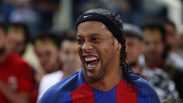 Former FC Barcelona player Ronaldinho, laughs as he enters the stadium during a friendly soccer match between the FC Barcelona and Real Madrid Legends, at the Camille Chamoun Sports City in Beirut, Lebanon, Friday,  - اسپوتنیک افغانستان  