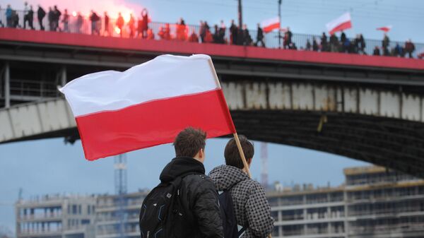 Молодые люди наблюдают за шествием националистов во время Национального праздника независимости Польши в Варшаве, 2015 год - اسپوتنیک افغانستان  