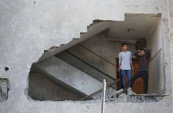 جوانان فلسطینی در زیر تعمیر ویران شده از اثر بمبارد هوائی اسرائیل - اسپوتنیک افغانستان  