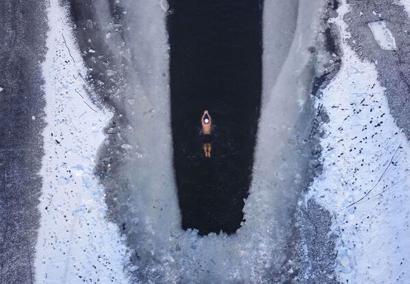 مردی در حال شنا در دریاچه یخ زده – شهر شینیان، چین - اسپوتنیک افغانستان  