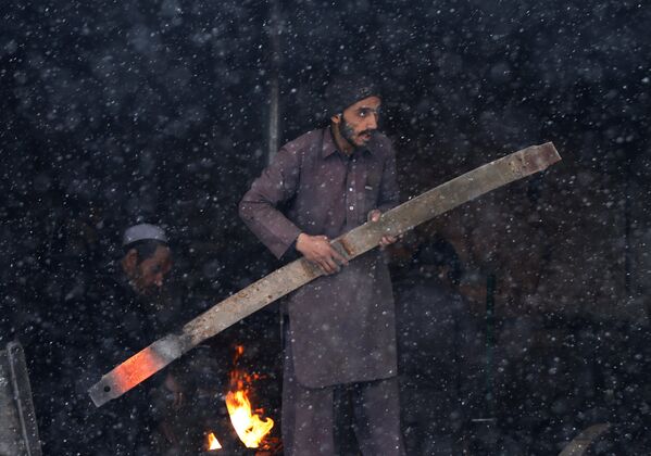 آهنگر در حال کار در جریان برف‌باری در کابل - اسپوتنیک افغانستان  