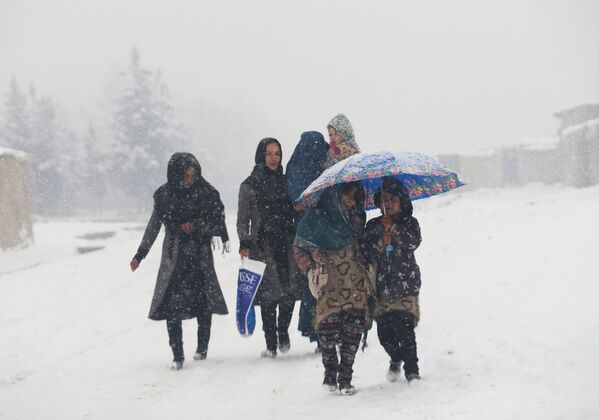 خانواده‌یی در حال قدم زدن در جریان برف‌باری در کابل - اسپوتنیک افغانستان  