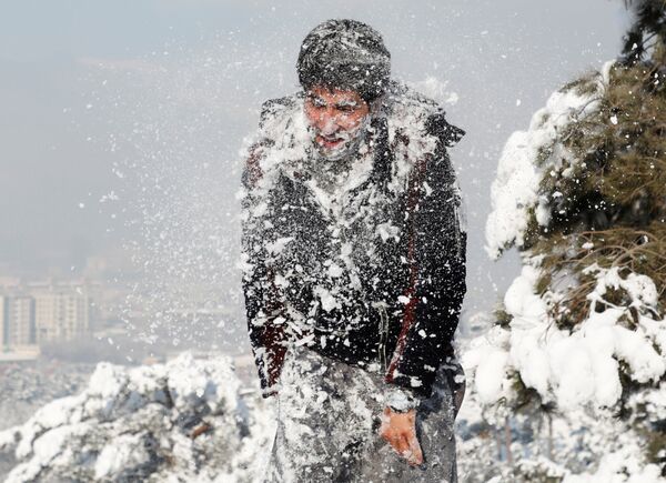 جوان افغان در حال برف‌بازی پس از بارش نخستین برف در کابل - اسپوتنیک افغانستان  