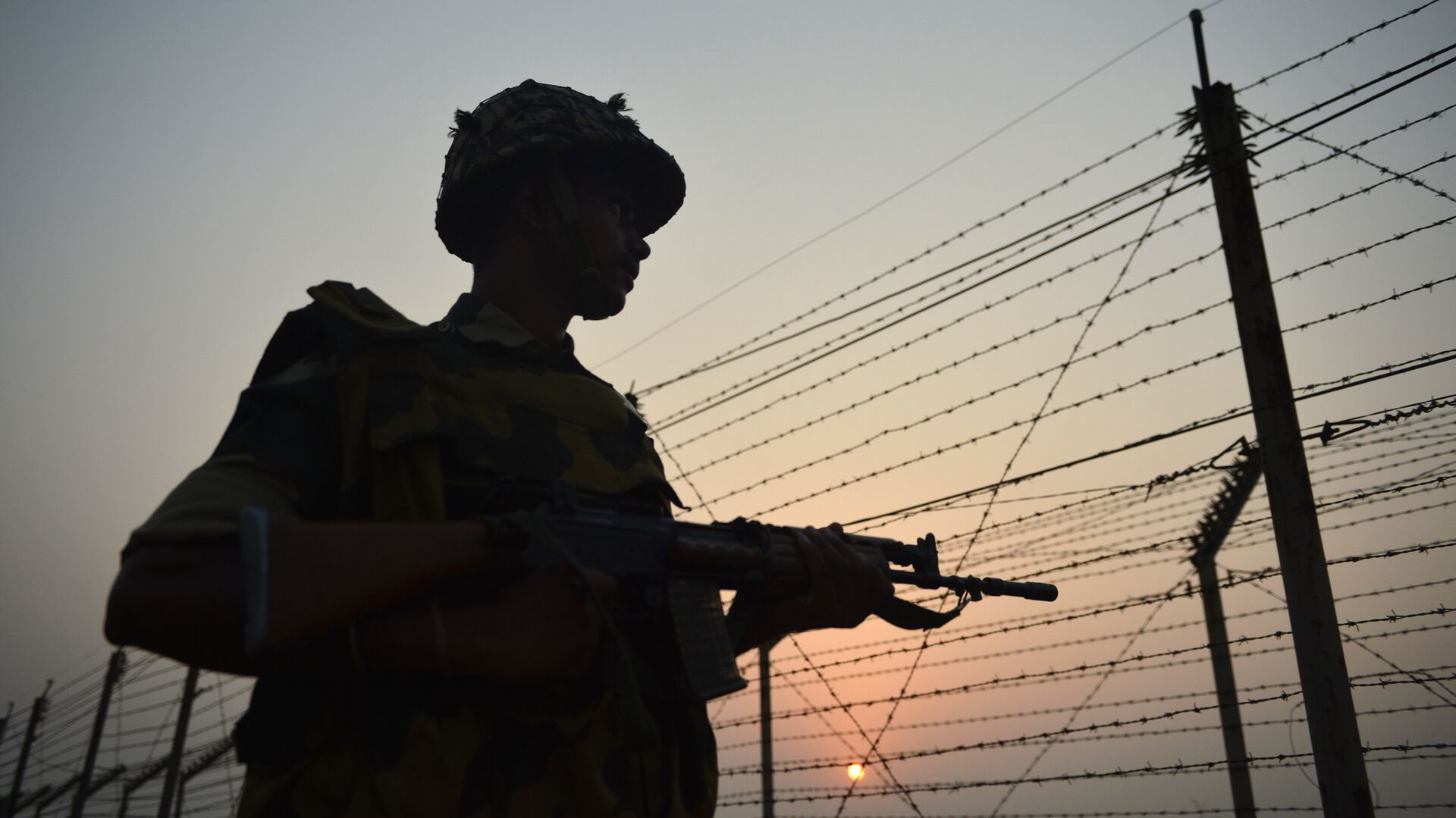An Indian Border Security Force (BSF) soldier patrols along a fence at the India-Pakistan border in R.S Pora, southwest of Jammu, on October 3, 2016 - اسپوتنیک افغانستان  , 1920, 06.02.2022