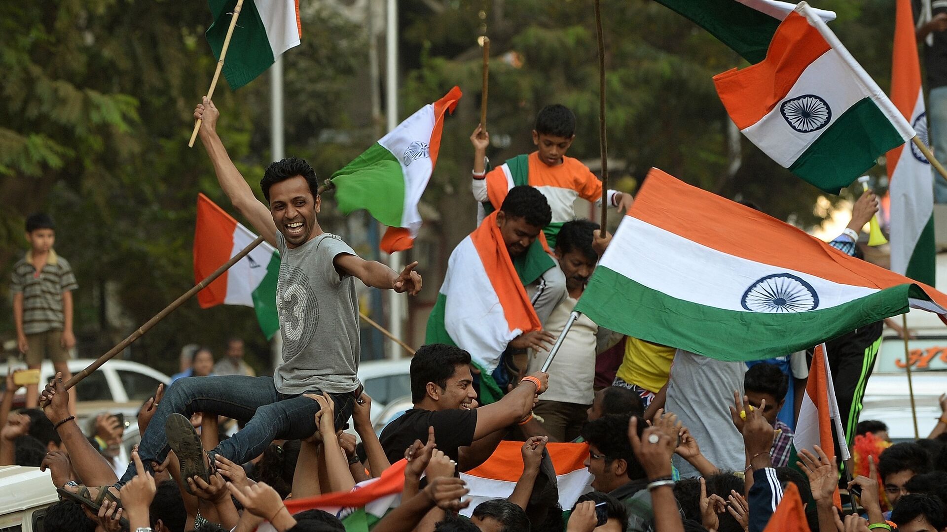 Indian fans wave national flags as they celebrate after India won the 2015 Cricket World Cup's cricket match against Pakistan, on the streets of Mumbai - اسپوتنیک افغانستان  , 1920, 18.08.2022